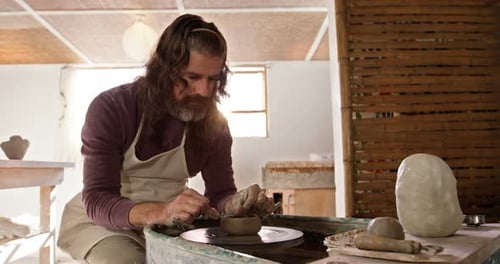 Man Shaping Clay on Potter's Wheel