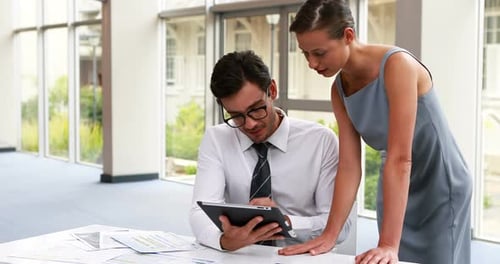 Team Discussing Tablet in Modern Bright Office