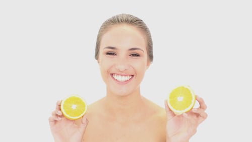 Smiling Woman Holding Sliced Oranges