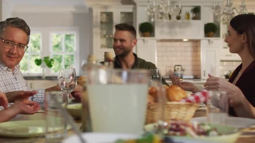 Family and Friends Gather Around Table for Meal