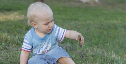 Kleinkind sitzt auf dem Gras