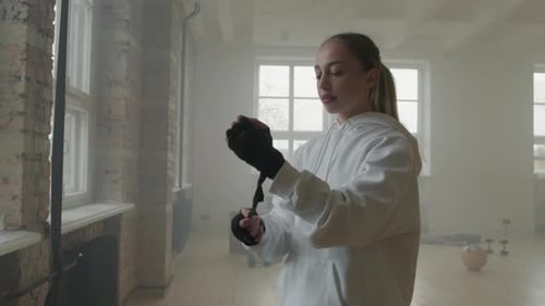 Woman Wrapping Hands for Boxing Training Preparation