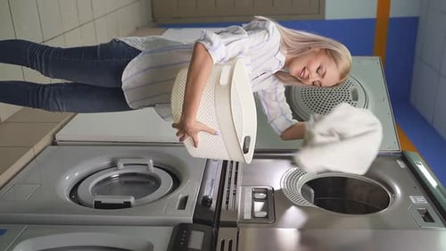 Woman Loads Laundry Into Washing Machine