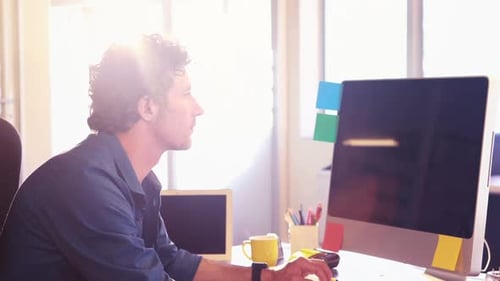 Young Adult Working at Computer in Office