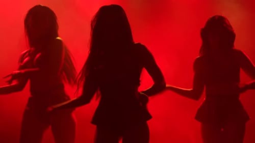 Silhouetted Women Dance in Red Light