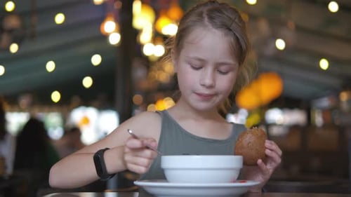 Child Girl Eating Soup and Tasty Burger in Restaurant