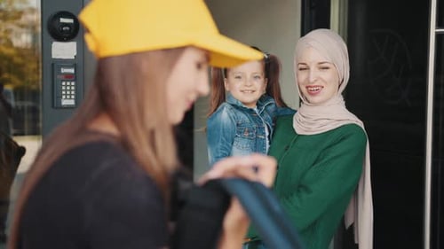 Delivery Worker Hands Package to Woman and Child