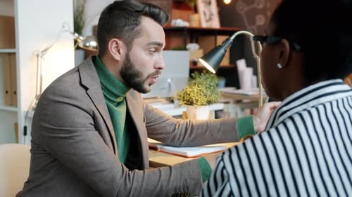 Man Discusses Strategy with Colleague in Office Setting