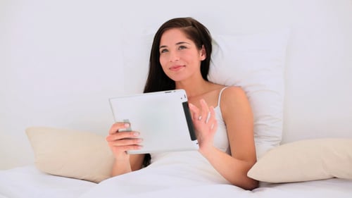 Woman Using Tablet in Bed