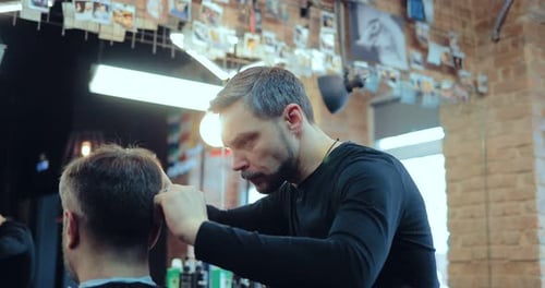 Stylish Barber Cuts Client's Hair in Urban Shop