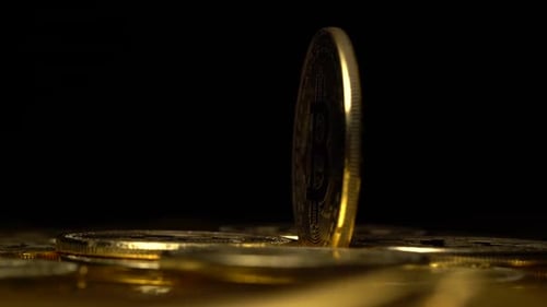 Golden Bitcoin Spinning, Standing on Cryptocurrency Pile