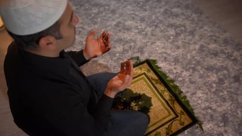 Man Praying Indoors on Prayer Rug
