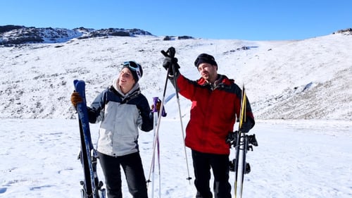 Couple Skiing in the Snowy Mountains