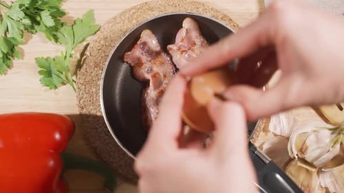 Egg Added to Bacon Frying in Pan