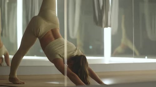 Young Woman Doing Yoga Flow in a Studio