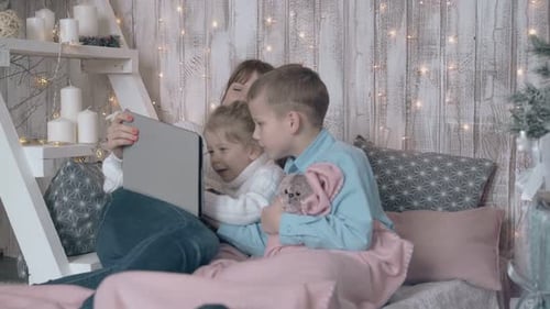 Mother and Children Looking at Tablet at Christmas