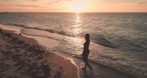 Young Woman Walking at Ocean Sand Beach at Sunset Aerial