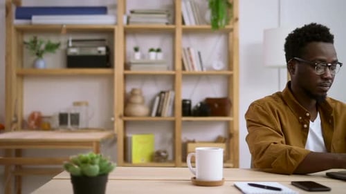 Black Man Typing on Laptop Concentrated on Work in Home Office Spbas