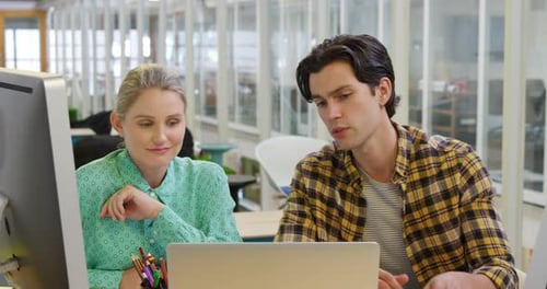 Young man and woman working in a creative office