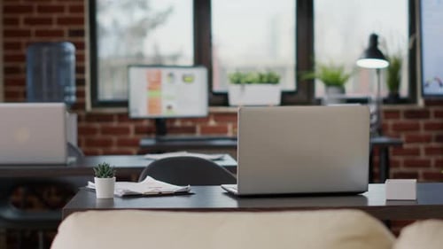 Nobody at Office Desk with Charts Documents and Laptop