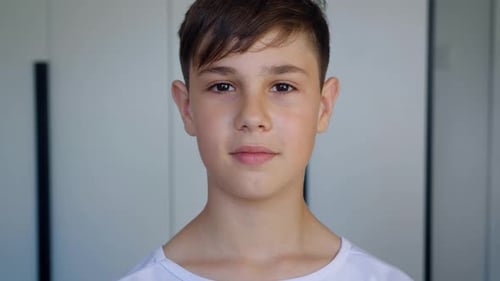 Portrait of Cute Boy of 10 Ages in White T-shirt Looking at Camera at Home.