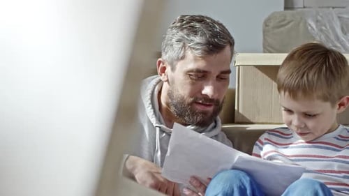Little Boy and Father Reading Manual