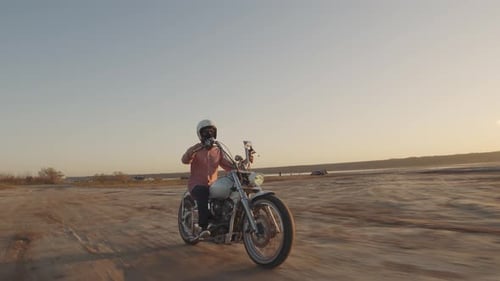 Motorcyclist Driving His Motorbike on the Dirt Road During Sunset Shot