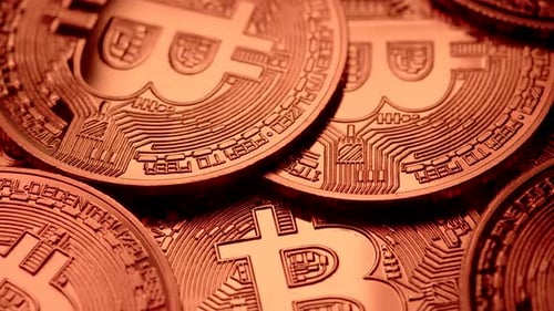 Closeup of Bitcoins Rotating Under Copper Light