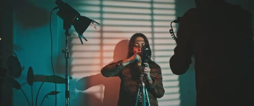 Woman Adjusting Vintage Video Camera in Studio