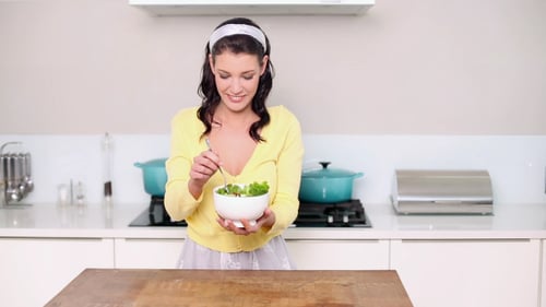 Woman Eating Healthy Salad in Modern Kitchen