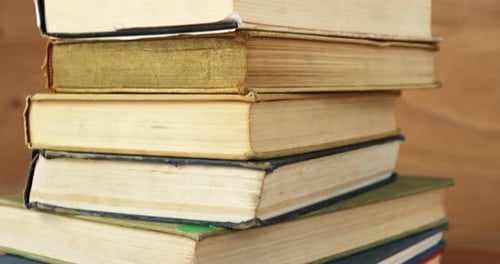 Stack of Old Books Rotating on Wooden Surface