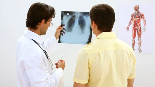 Doctor Examining X-Ray with Patient in Hospital