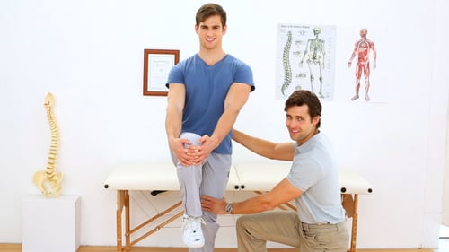 Man Exercises Leg with Physical Therapist