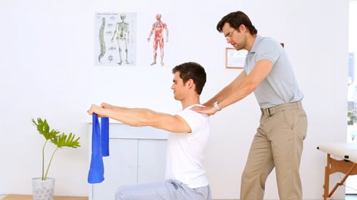 Man Works with Physical Therapist on Resistance Band Exercise
