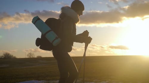 Woman Hiking with Poles at Sunrise