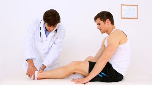 Doctor Examines Patient's Ankle in Bright Office