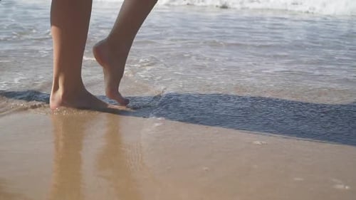 Female Bare Feet Walking on the Wet Sand on the Beach. Slow Motion