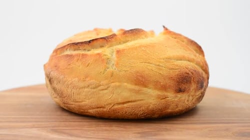 Freshly Baked Loaf of Bread on Wooden Board