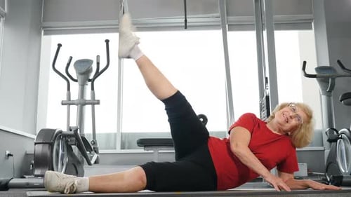 Woman Exercising on Yoga Mat in Gym