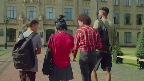 Back View of Diverse Multicultural College Friends Walking Together to Study