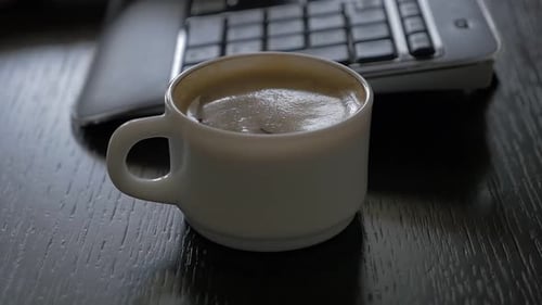 Arbeitsplatz-Kaffeetasse nach dem Eingeben der Tastatur High Definition 1080p FullHD Zeitlupenaufnahmen