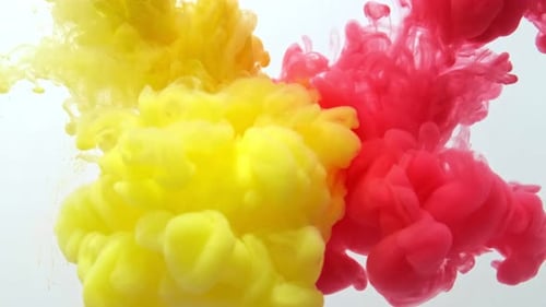Rote und gelbe Tinte bewegt sich im Wasser auf weißem Hintergrund. Im Wasser wirbelnde Acryltinte.