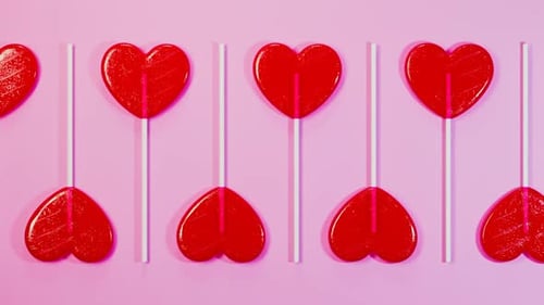 Animated Seamless Loop of Red Heart Lollipops on Pink Background