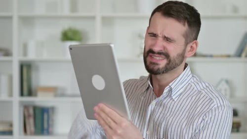 Man Frustrated with Tablet Indoors