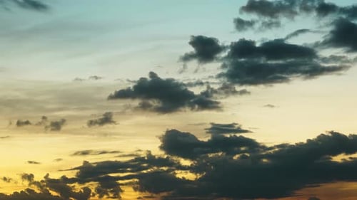 Fluffy Clouds Floating on Brightcolored Sunsetting Sky