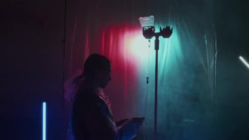 Person in Futuristic Lab Adjusts Medical IV Drip