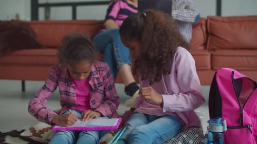 Kreative Kinder beim Zeichnen im Notizbuch zu Hause