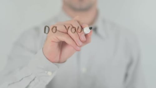 Man Writes Question with Marker on Glass