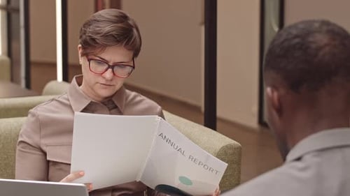 Business Professionals Reviewing Annual Report in Office