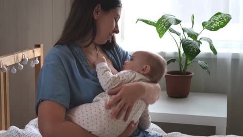 Mother holding baby in her arms at home
